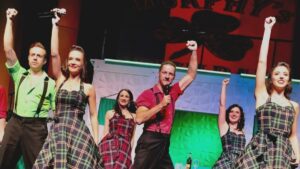 Several cast members of Dublin’s Irish Tenors and The Celtic Ladies on stage with their arms raised